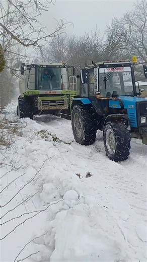 THE TRACTOR IS PULLING THE COMBINE HARVESTER