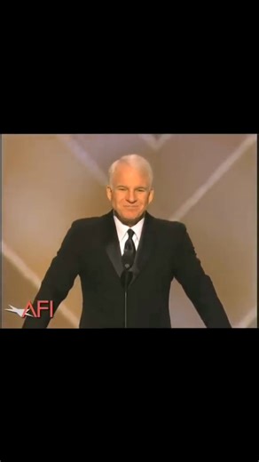 Steve Martin takes the stage with his trademark dry-wit and self-awareness, immediately setting a playful, light-hearted tone. He begins by saying that this isn't really a full "Life Achievement Award" for Tom Hanks. Rather, he dubbed it the "AFI Mid-Life Achievement Award", poking fun at the fact that Hanks was relatively young compared to typical recipients. From there he weaves in affectionate jabs and comedic asides about Hanks's career and persona: referencing Hanks's all American likabilit
