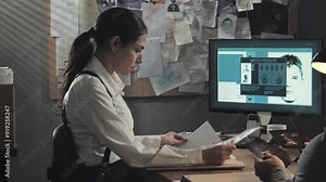 two detectives sit at the desk in office examining murder evidences,police investigator couple working on criminal case searching browsing photos and files of the crime investigation