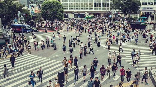Crowds of people cross a street junction - Free Stock Video