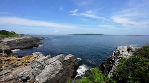 Atlantic ocean waves crashing into rocky shoreline with sea level rising and falling with the waves