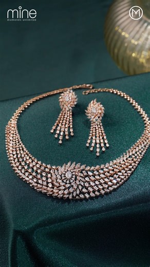 A statement of style and sophistication.​ This stylish set features a distinctive knot-style necklace where sweeping rows of fancy-cut diamonds cross over at the centre, creating a bold, signature shape. The earrings complement it with a radiant flared top and cascading natural diamond strands that add movement and brilliance. Heavy in look and premium in craftsmanship, this set is perfect for high-glamour occasions, receptions, and evening wear where a standout presence is a must.​ Visit the Ma