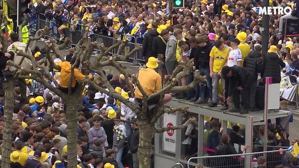 Leeds United fans line the streets as parade buses enter city centre