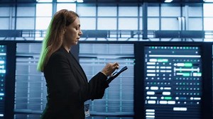 Technician doing checkup using tablet to prolong data center electronics life span and avoid downtime. Employee walking in server room, monitoring server infrastructure using digital device, camera A