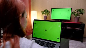 Television Computer Green Screened Woman - Full HD. Woman watches television and uses computer with green screen shot behind model's shoulders