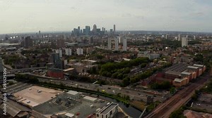 Flying over London with a beautiful city of London district and Canary Wharf view on the horizon.
