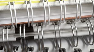 Tailor binding the edges of lightweight work shorts hem focusing on neat reinforced trim adding style and extra wear resistance for hot weather workwear.