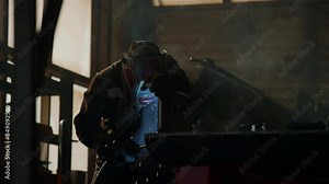 Professional welder in safety mask using blow torch while welding metal at workbench in industrial factory Stock Video