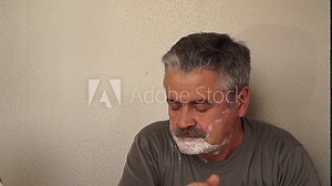 a man shaves his neck with a straight razor
