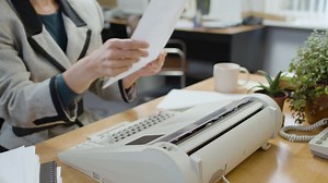 Free stock video - Caucasian female worker typing on typewriter