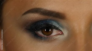 Girl with an evening make up closes and opens the eyes. Close up. Slow motion