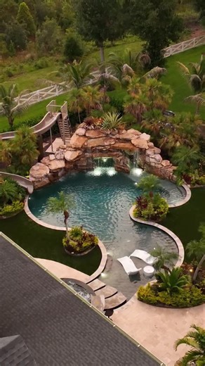 43K views · 4.6K reactions | This backyard has a huge grotto, a waterslide, a big elevated spa with a swim-up bar, a sun shelf area, and a big swimming and jumping play area. This place is laid out for entertaining. #insanepools #lucaslagoons #pool #poolbuilders #backyard #luxurylife #waterslide | Lucas Lagoons | Facebook