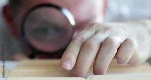 Employee looks through magnifying glass and searches for required document. Archive concept