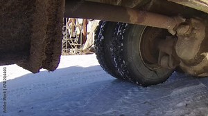 Heavy duty driveshaft and differential on a grain truck moving around a snowy farmyard