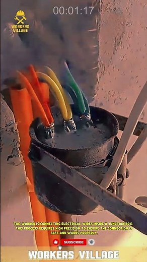The worker is connecting electrical wires inside a junction box.