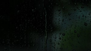 Download Rain drops on the glass. Small raindrop rests on glass while raining. for free
