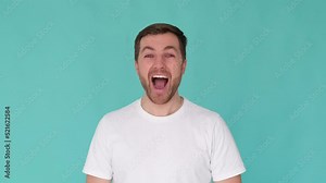 Close up of a surprised man shouting wow and looking at the camera in surprise. Happy bearded man