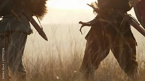 Two medieval warriors Viking are fighting with swords and shields. Contre-jour