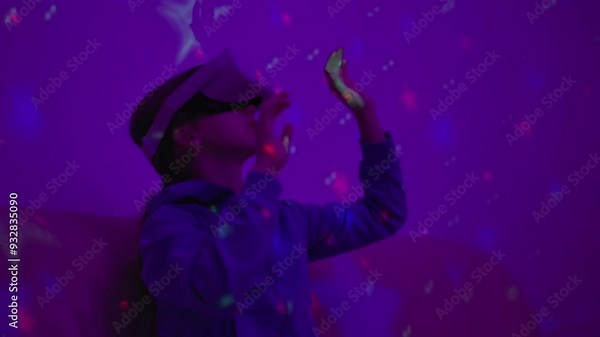 Girl Using Virtual Reality Headset And Looking Around At Interactive Technology With Colorful Illumination. VR Entertainment Immersive. Girl Wearing VR Headset in World of Virtual Reality Interacting.