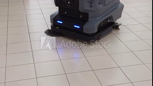 Industrial floor scrubber cleaning tile floor in real time, displaying professional cleaning equipment for maintenance process