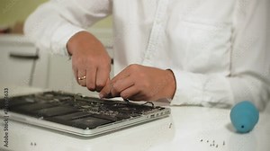 A man is repairing a laptop. The concept of computer repair. Close up of man repair laptop motherboard with a screwdriver. Maintenance of the hardware of the motherboard. Disc holder, computer repair Stock Video