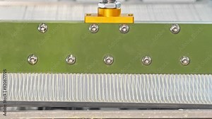 Industrial chemistry: At the factory, glue is industrially applied over a metal plate in order to create structures. Close up. Slow motion