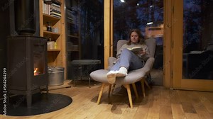 Evening Fireplace Scene in a Wooden Cabin - video of Woman reading a book