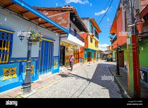 GUATAPE, COLOMBIA: COULD this rainbow-painted town be the most colourful place in the world? Stunning video and pictures have revealed the spectacular town where everything from the buildings to the steps are painted in bright, vibrant colours. The incredible images have a surreal feel as the multi-coloured houses stand in stark contrast to the aerial view of the lush green surrounding area. The snaps were taken in Guatapé, Colombia by Canadian photographer Jessica Devnani (27) from Toronto usin