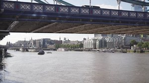 Cinematic view under Tower Bridge in London, Thames river and boat