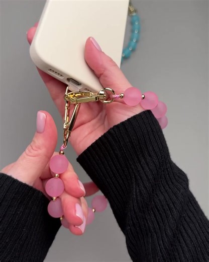 A bright, minimalist phone charm with smooth matte acrylic beads, available in soft pink and sky-blue tones, finished with gold-tone spacer beads and hardware for a clean, elevated look. The soft matte finish adds a modern pop of color that’s easy to style every day. Details:• Phone compatibility: Includes a clear phone tether tab (ultra-thin) designed to fit inside most phone cases with a closed bottom.• Works with your existing phone case — place the tab inside the case and connect the charm t