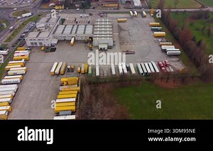 High aerial view of a busy logistics and distribution center. Trucks and semi-trailers loading and unloading cargo at the warehouse docks Stock Video Footage - Alamy