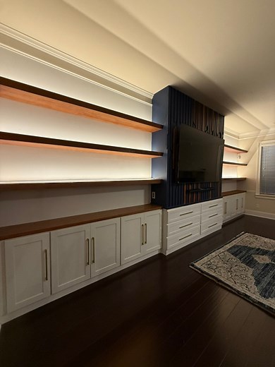 9.2K views · 107 reactions | Transformed the living room’s focal point in Hampton, GA with a custom entertainment system! Featuring sleek cabinets, six spacious drawers, a stunning blue and wood green accent wall, and illuminated white oak shelves. #woodworking #LivingRoomInspiration #carpenter #Georgia #entrepreneur #LivingRoomGoals #LivingRoomDesign #LivingRoomInspo #artist #luxuryhomes #LuxuryLiving #luxuryhomes #shelvingideas #customwoodwork | Fields Home Improvements | Facebook