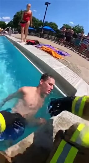 @short_circuit_ai | A firefighter pulls an unconscious swimmer from a crowded public pool and immediately begins life-saving CPR on the pool deck. Bystanders... | Instagram
