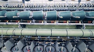 Industrial sewing mechanism with spinning spools. Textile production, clothes manufacturing concept.