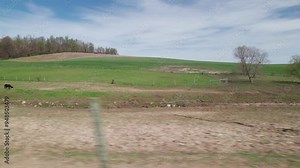 Driving around small town America in Ohio countryside, moving past wood buildings, old barns, farm land, crops, trees, and large fields in conservative rural area outside Columbus and Danville, OH