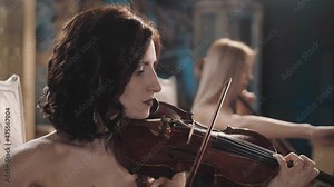 cute girls play in a beautiful room. violin and cello. repetition . duet of musicians. close-up