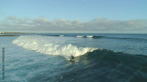 AERIAL Pro male surfer on surfboard riding the waves and falling in the early morning time. Sunrise exercise for a fit sportsman enjoying his action packed vacation. Surfers paradise in Canary Islands