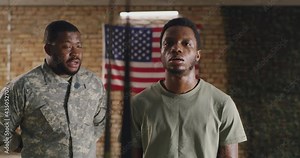 African American trainer instructing soldier during suspension training