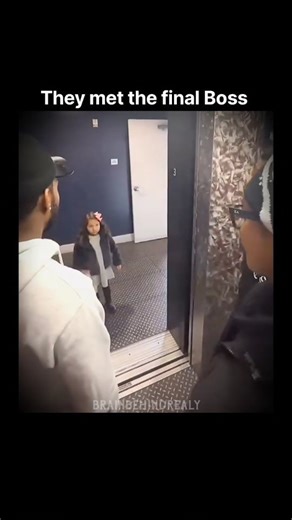 reality on Instagram: "Wait for end 🗣️ In a short clip filmed inside an elevator, three to four adult men stand facing the open doors, initially holding up their middle fingers toward the camera. As the elevator doors open, a small girl is seen standing outside in the hallway. Immediately after noticing her presence, the men lower their hands and close their fists, stopping the gesture. The girl then looks toward the elevator and raises her own middle finger in response. The elevator doors begi