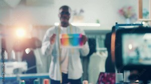 Camera is filming and african designer talking about colours