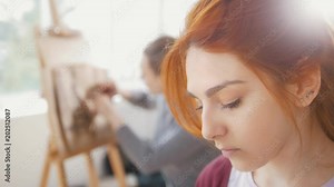 Young female woman in front of artist draws sketches of woman figure