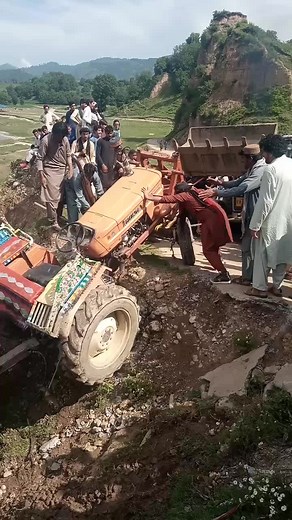 South Asian Men Struggling to Right a Tipped Tractor