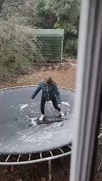 Girl Trips and Falls While She Repeatedly Tries to Jump on Frozen Trampoline - 1401078