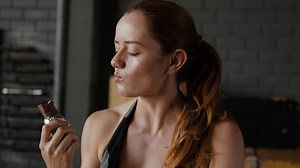 Woman eating a protein bar in the gym | Free Stock Video Footage