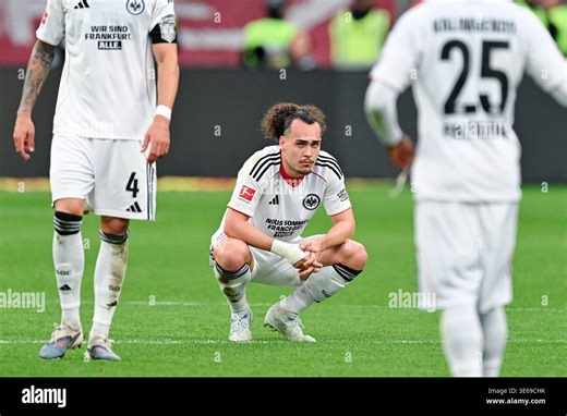 05 April 2026, Hesse, Frankfurt/Main: Soccer, Men, Bundesliga, Eintracht Frankfurt - 1. FC Köln, Matchday 28, Deutsche Bank Park, Arthur Theate (M, Eintracht Frankfurt) squats on the pitch after the match. The match ended 2:2. Photo: Uwe Anspach/dpa - IMPORTANT NOTE: In accordance with the regulations of the DFL German Football League and the DFB German Football Association, it is prohibited to utilize or have utilized photographs taken in the stadium and/or of the match in the form of sequentia