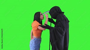 Grim reaper in Halloween costume with a scythe being scolded and slapped by a woman on green screen