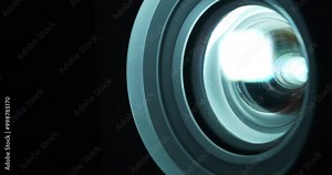 Cinema hall. Projector lens in operation close-up. Movie is shown through projector. Lenses of working projector change color. Light of different colors passes through the lenses
