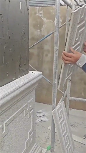 construction worker installing decorative wall panels with geometric patterns