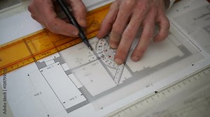 Architect drawing blueprints plan, graph, design, geometric shapes by pencil on large sheet of Tracing paper at office desk. Engineer hands, Working with triangle ruler and pencil