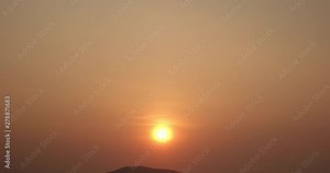 Time lapse footage of the sun in beautiful sunset over mountain. High-quality free stock video footage of time lapse or timelapse of the large orange sunset into the horizon above. Dramatic sunset sky